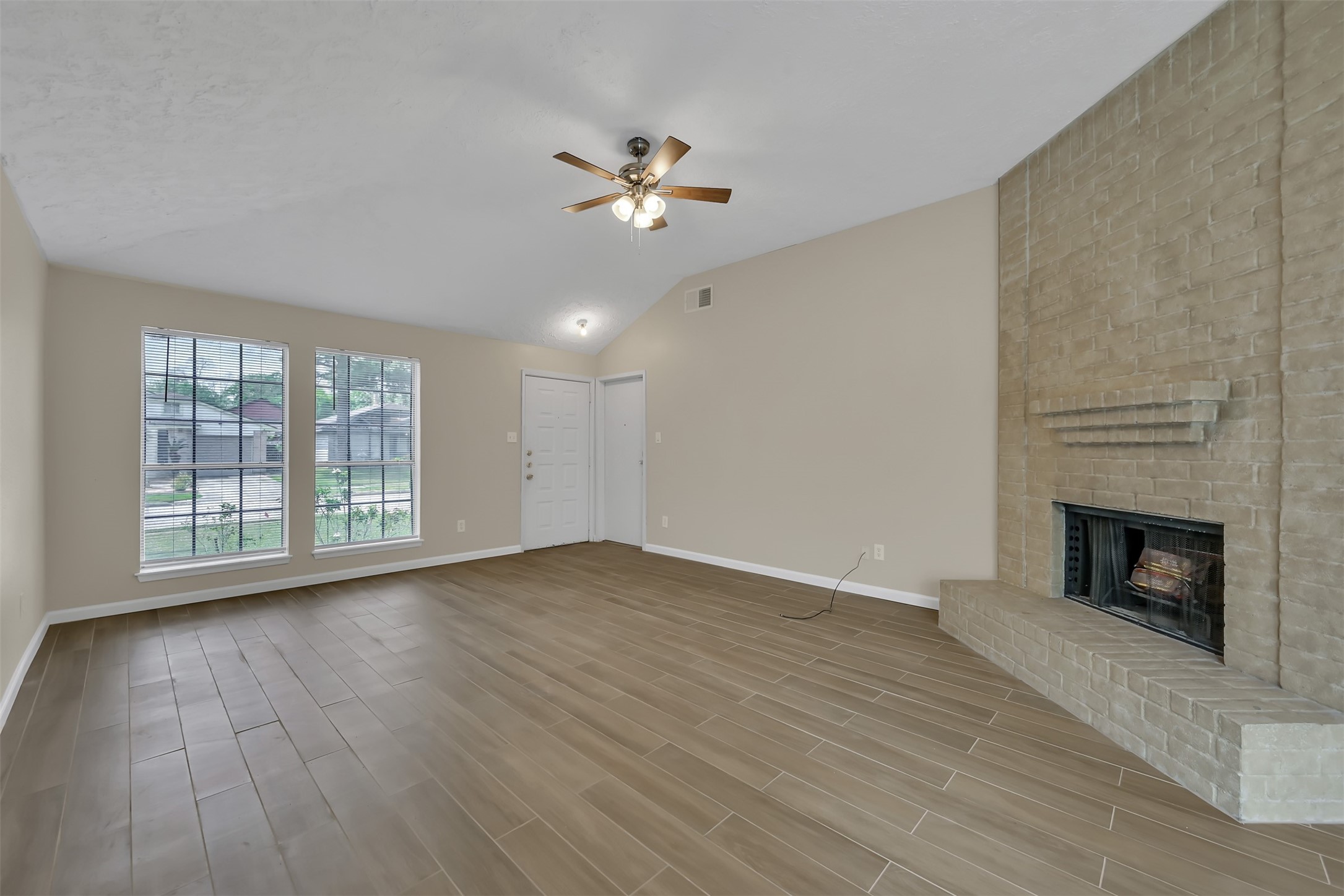 22112 Peachglen Lane Spring, TX 77373 - Photo 4 of 17 a view of an empty room with wooden floor fireplace and a window