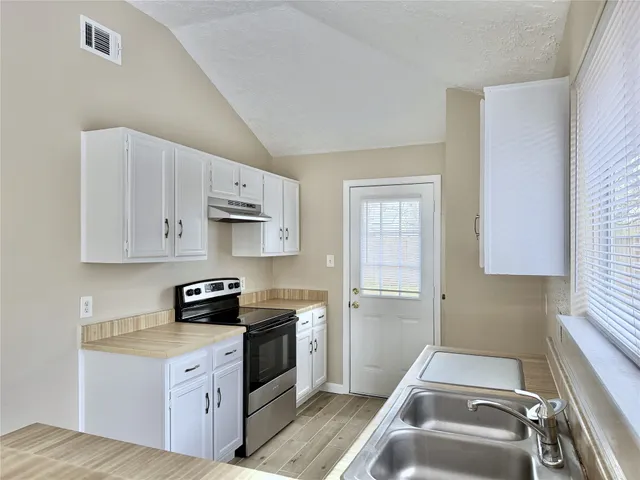 a kitchen with a sink stove and cabinets