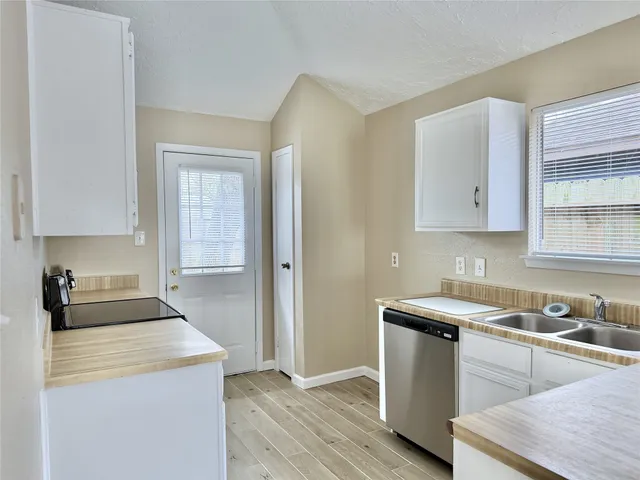 a kitchen with granite countertop white cabinets and white appliances