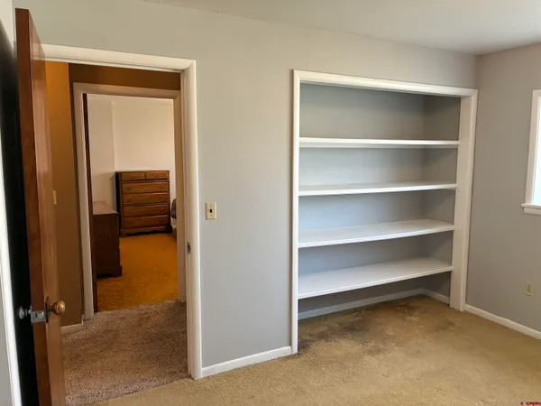 a view of walk in closet with empty racks