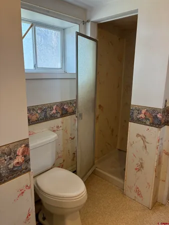 a bathroom with a toilet and a shower