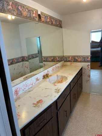 a bathroom with a granite countertop sink a mirror and vanity