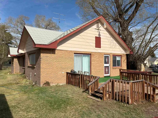 a view of a house with wooden deck front of house