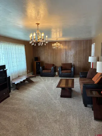 a living room with furniture and a chandelier
