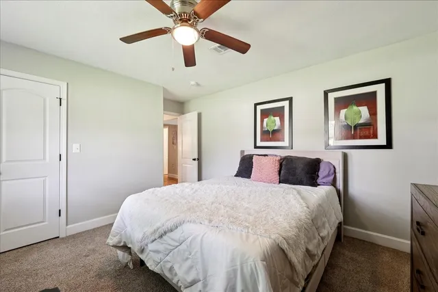 a bedroom with a large bed and a chandelier