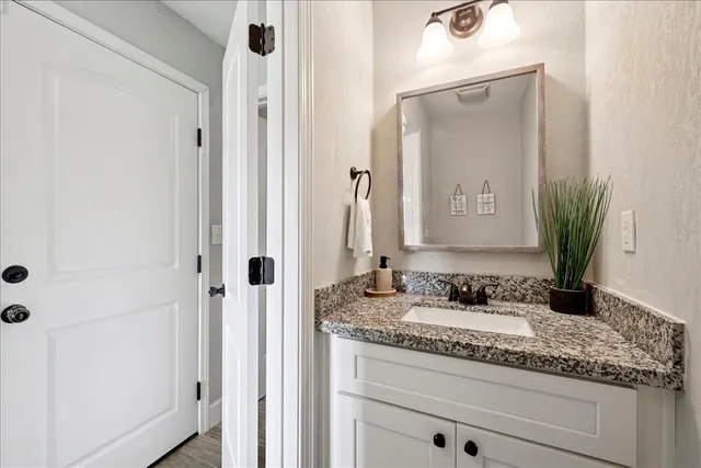 a bathroom with a granite countertop sink and a mirror