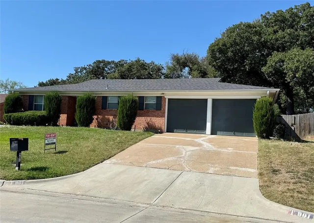 a front view of a house with a yard and potted plants