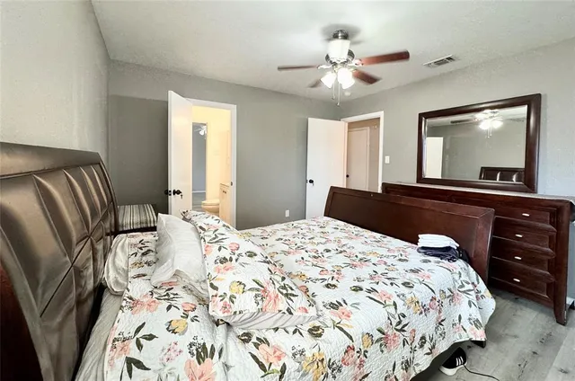 a bedroom with a large bed and a chandelier
