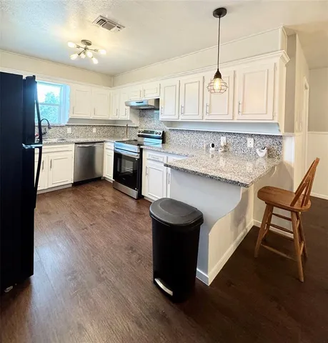 a kitchen with a sink cabinets and wooden floor