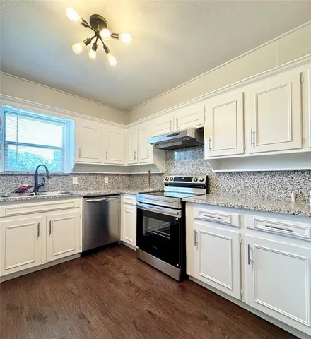 a kitchen with stainless steel appliances granite countertop a sink and cabinets