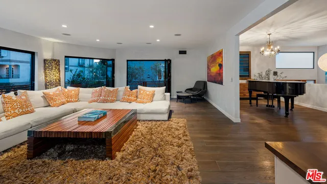 a large white kitchen with a large window and furniture