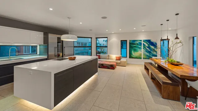 a large kitchen with stainless steel appliances a large counter top a stove and a sink