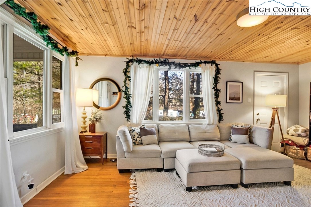 a living room with furniture a large window with a chandelier