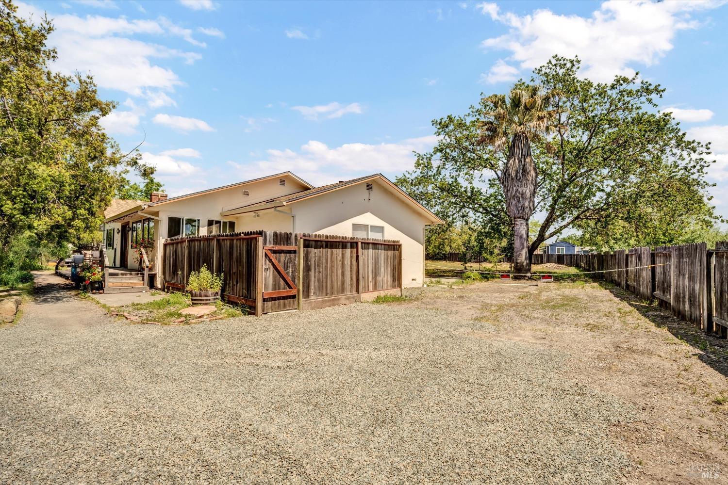 a view of a large house with a big yard and large trees