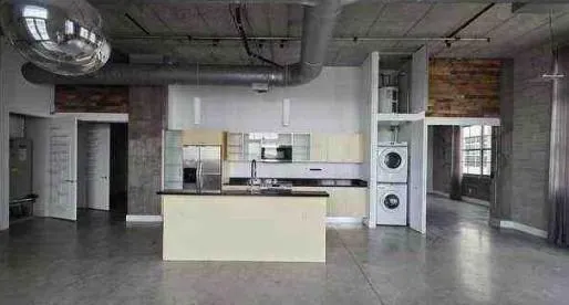 a kitchen with stainless steel appliances granite countertop a sink and a refrigerator