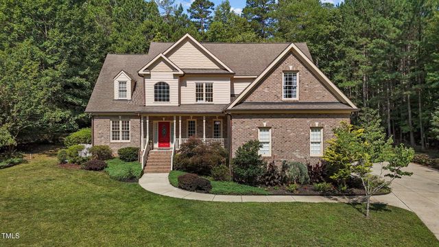 a front view of a house with a yard and trees