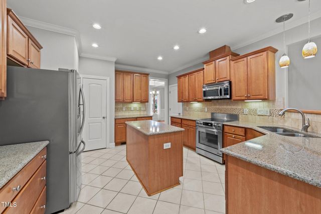 a kitchen with stainless steel appliances granite countertop a refrigerator stove and sink