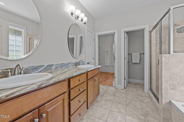 a spacious bathroom with a granite countertop sink mirror and a shower
