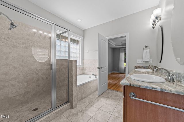 a spacious bathroom with a shower sink and mirror