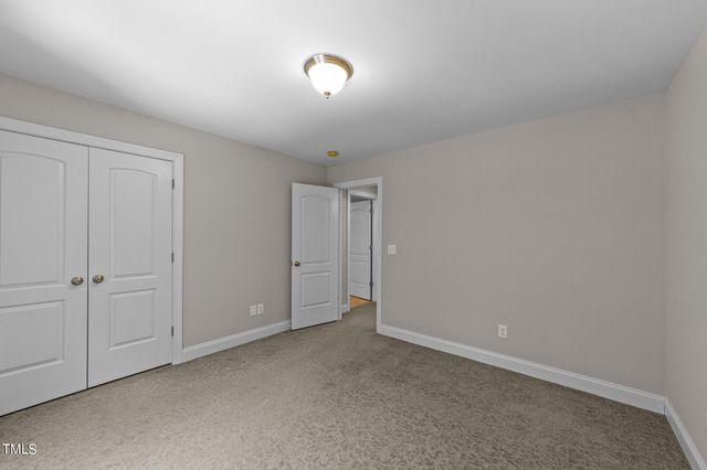 a view of an empty room and chandelier fan