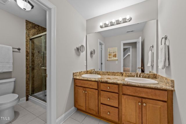 a bathroom with a granite countertop sink a toilet and a mirror