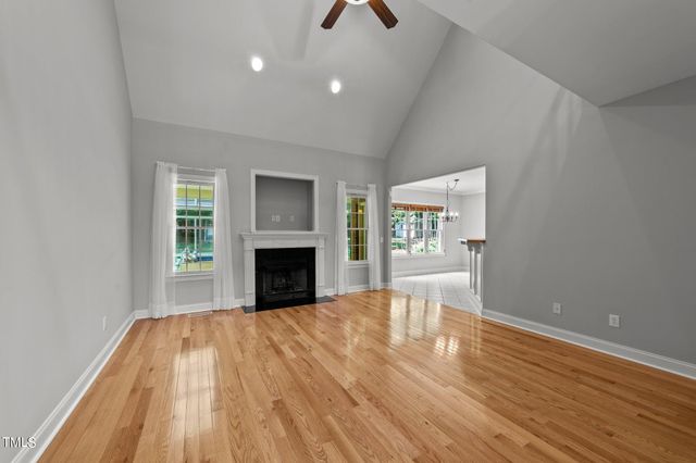 a view of empty room with wooden floor and fireplace