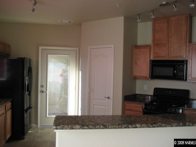 17000 Wedge Parkway, Unit 2124 Reno, NV 89511 - Photo 2 of 6 a living room with stainless steel appliances kitchen island granite countertop a refrigerator and a stove top oven