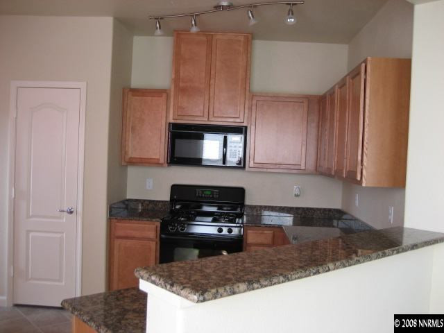 17000 Wedge Parkway, Unit 2124 Reno, NV 89511 - Photo 3 of 6 a kitchen with granite countertop a sink a stove and cabinets