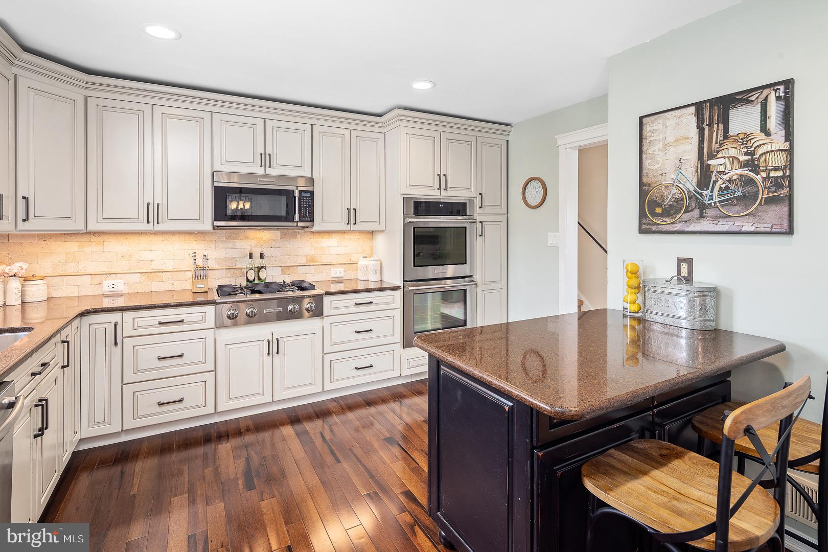 8 Valley Road Hamilton, NJ 08690 - Photo 7 of 31 a kitchen with stainless steel appliances granite countertop a stove a sink dishwasher and a microwave with wooden floor