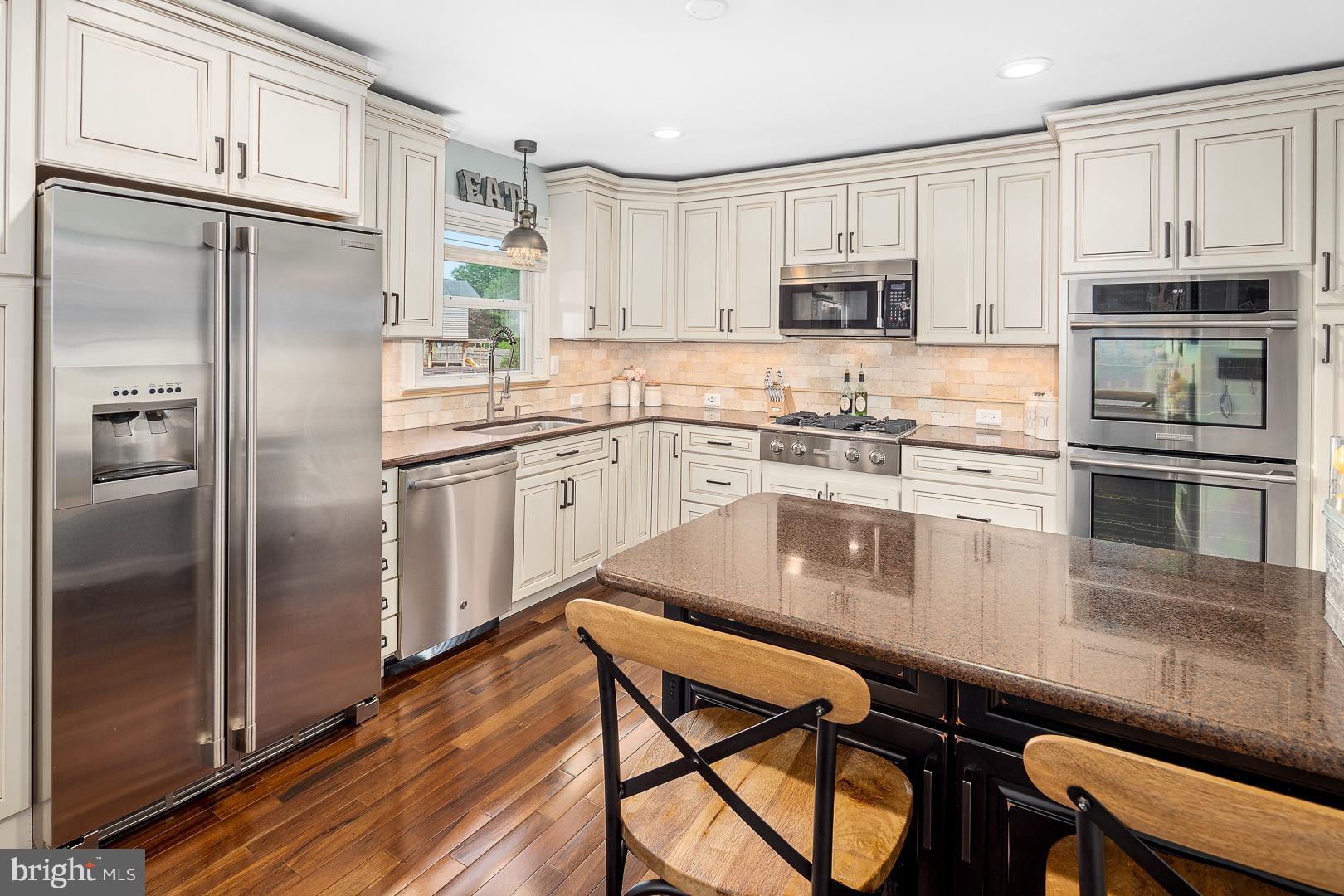 8 Valley Road Hamilton, NJ 08690 - Photo 8 of 31 a kitchen with stainless steel appliances granite countertop a refrigerator a stove a sink a dining table and chairs with wooden floor
