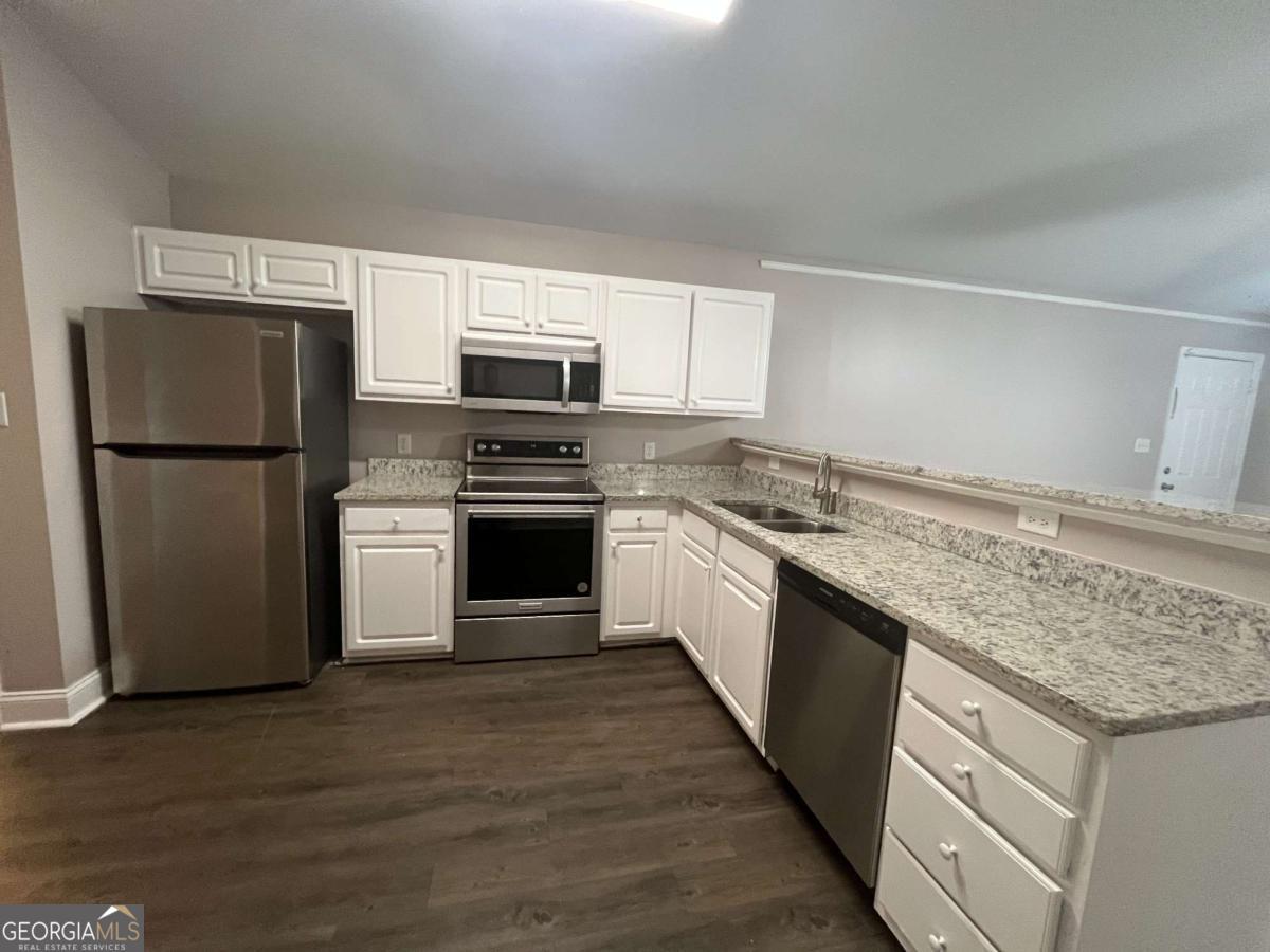 565 Rustwood Drive Athens, GA 30606 - Photo 3 of 16 a kitchen with a refrigerator sink and cabinets