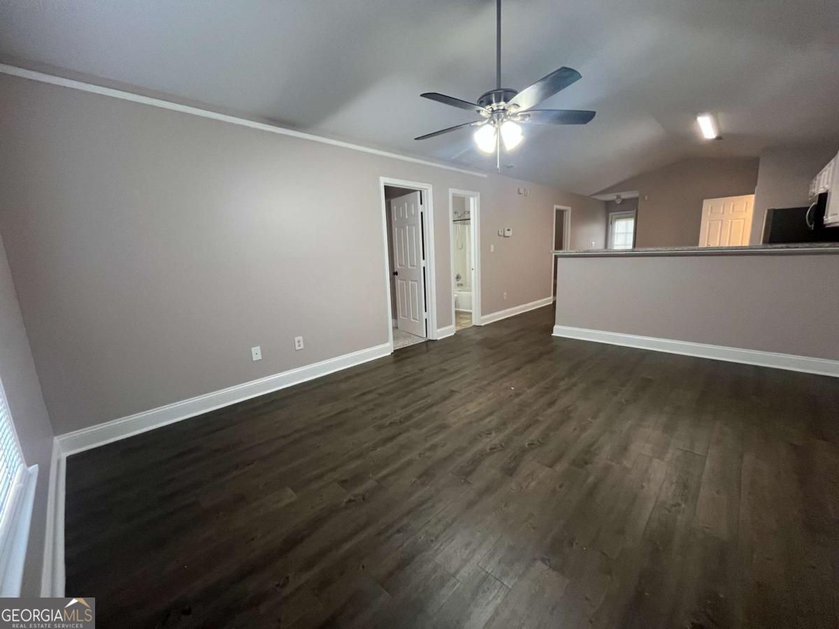 565 Rustwood Drive Athens, GA 30606 - Photo 4 of 16 a view of an empty room with wooden floor and a ceiling fan