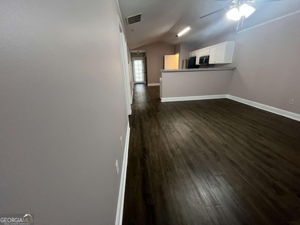 565 Rustwood Drive Athens, GA 30606 - Photo 6 of 16 a view of a hallway with wooden floor and a kitchen