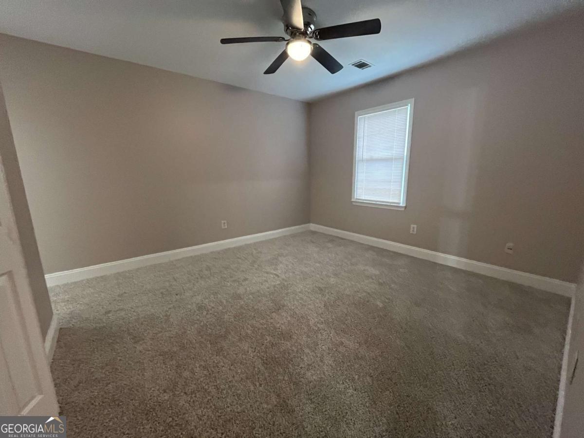 565 Rustwood Drive Athens, GA 30606 - Photo 8 of 16 an empty room with a window and a fan