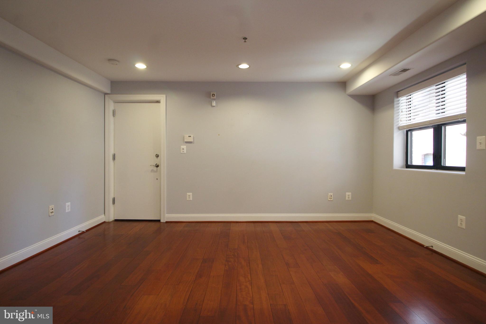 1354 Euclid Street Northwest, Unit 303B Washington, DC 20009 - Photo 6 of 16 wooden floor in an empty room with a window