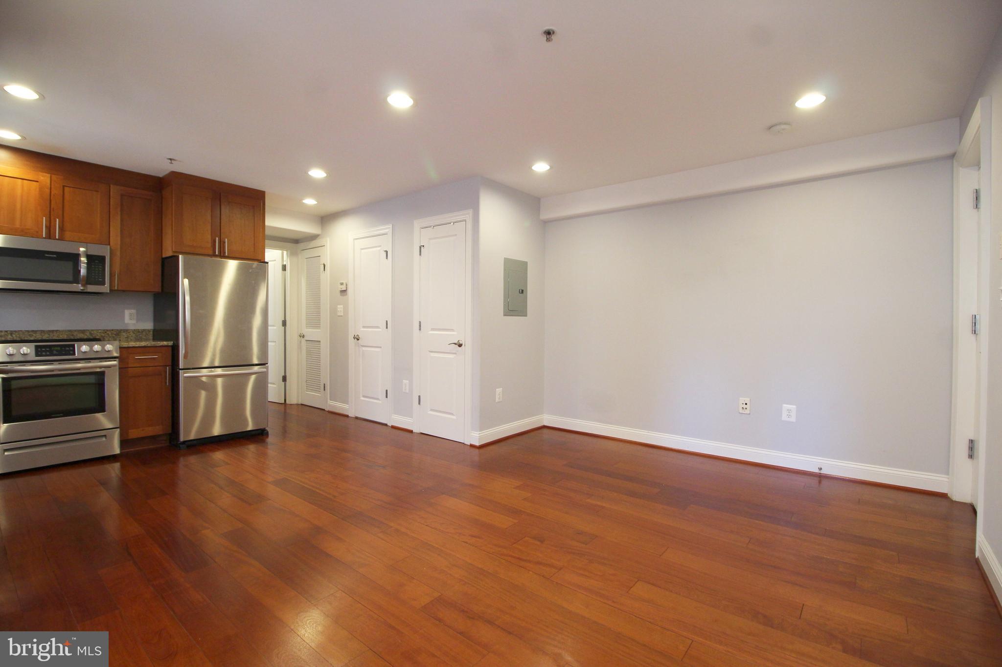 1354 Euclid Street Northwest, Unit 303B Washington, DC 20009 - Photo 7 of 16 a view of kitchen with stainless steel appliances a refrigerator and wooden floor