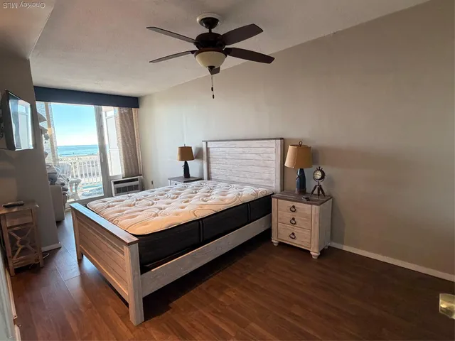 a living room with hard wood floors and a bed