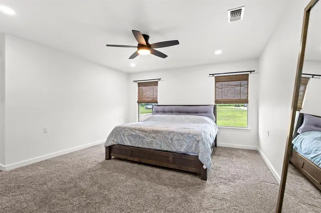 a spacious bedroom with a bed and a window