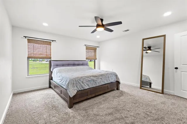 a spacious bedroom with a bed and a window