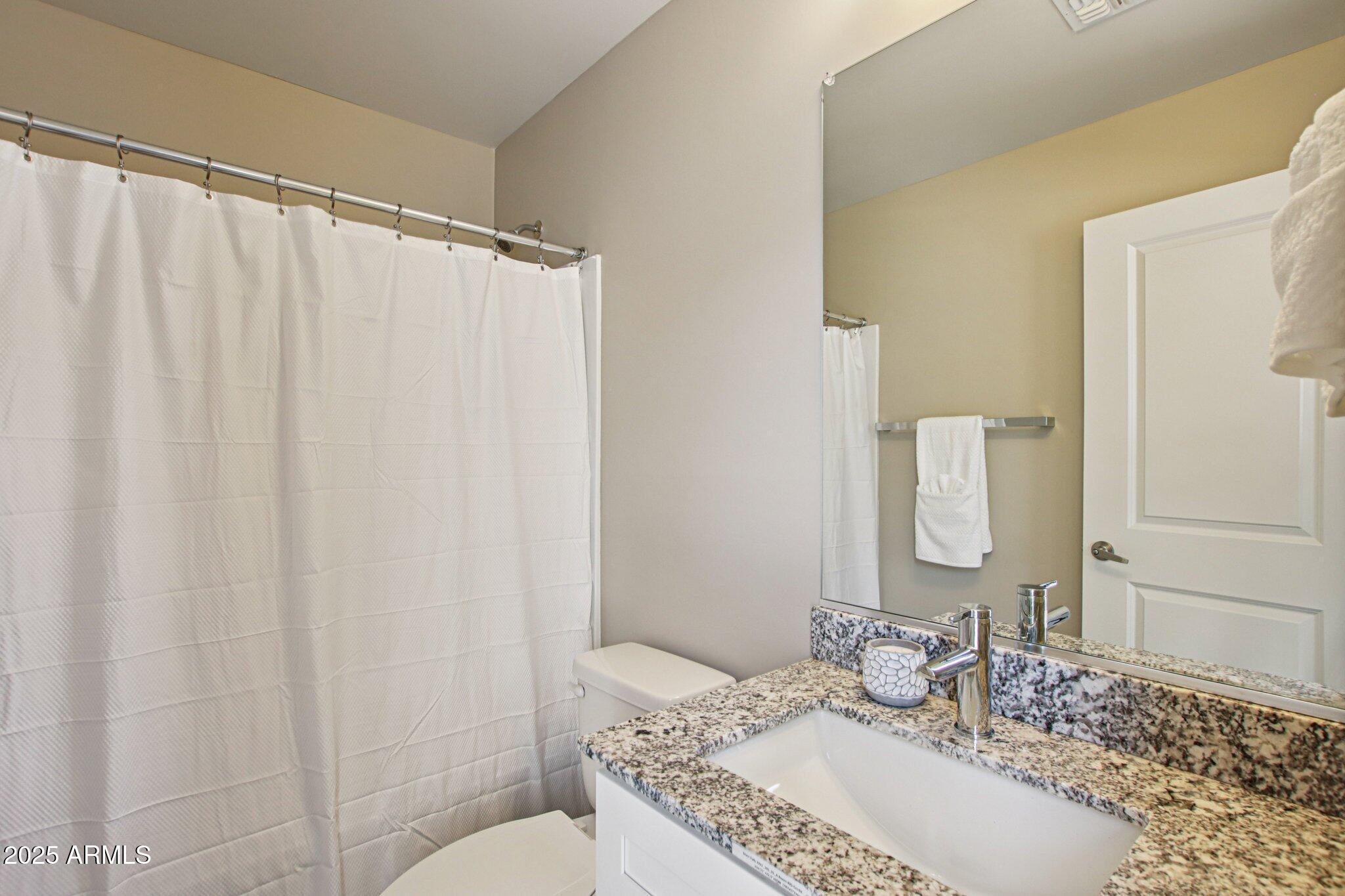 1927 South Recker Road, Unit 163 Mesa, AZ 85206 - Photo 31 of 34 a bathroom with a granite countertop sink and a mirror