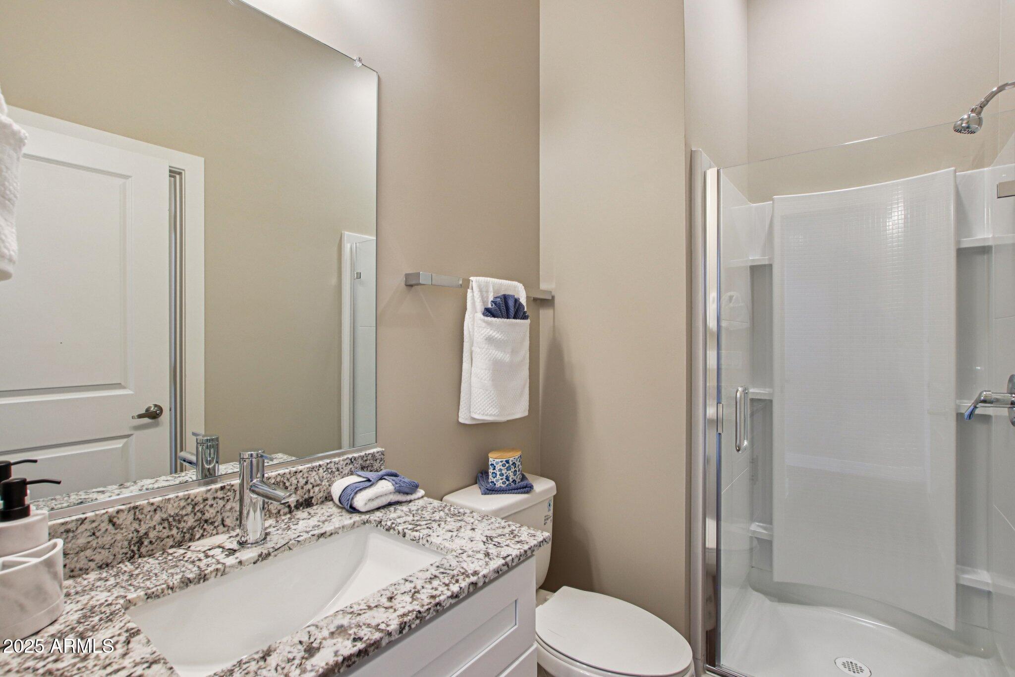 1927 South Recker Road, Unit 163 Mesa, AZ 85206 - Photo 32 of 34 a bathroom with a granite countertop sink toilet and shower