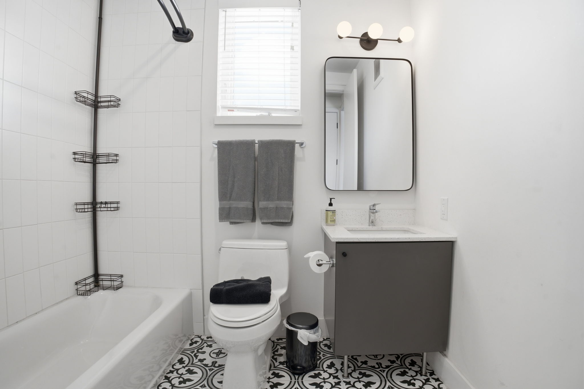 2709 East 5th Street, Unit 1306 Austin, TX 78702 - Photo 11 of 28 Crisp white tiling and a striking patterned floor elevate this well-appointed bathroom.