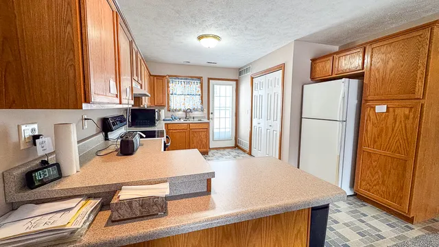 a kitchen with a sink a stove top oven and cabinetry