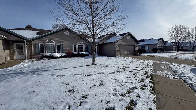 a front view of a house with a yard covered in snow