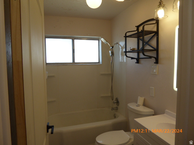 533 East 100 North Price, UT 84501 - Photo 5 of 6 Bathroom featuring a built-in bathtub with shower, white vanity with integrated sink, and an opaque window