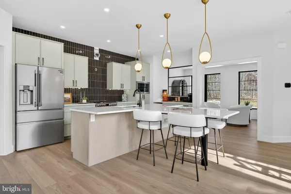 a living room with stainless steel appliances kitchen island granite countertop a refrigerator and a stove top oven