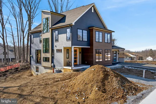 a front view of a house with a yard covered with snow