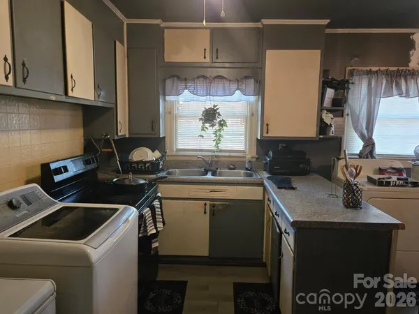 a kitchen with a sink cabinets and a stove top oven