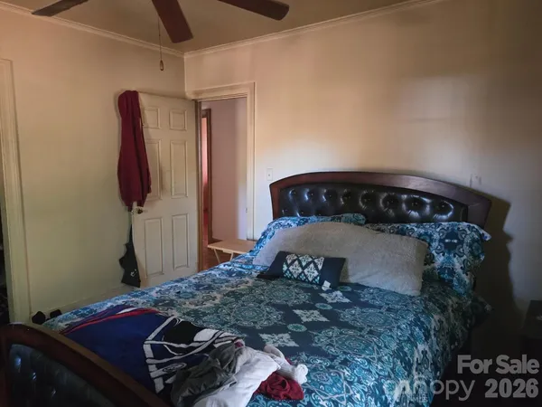 a bedroom with a bed and teddy bear on bed