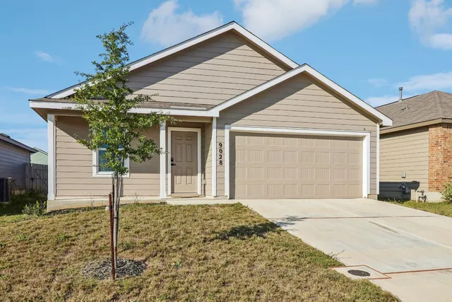 a front view of a house with a yard and garage